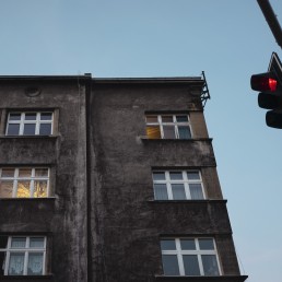 Katowice, ulica Powstańców. Modernistyczny budynek mieszkalny. I czerwone światło