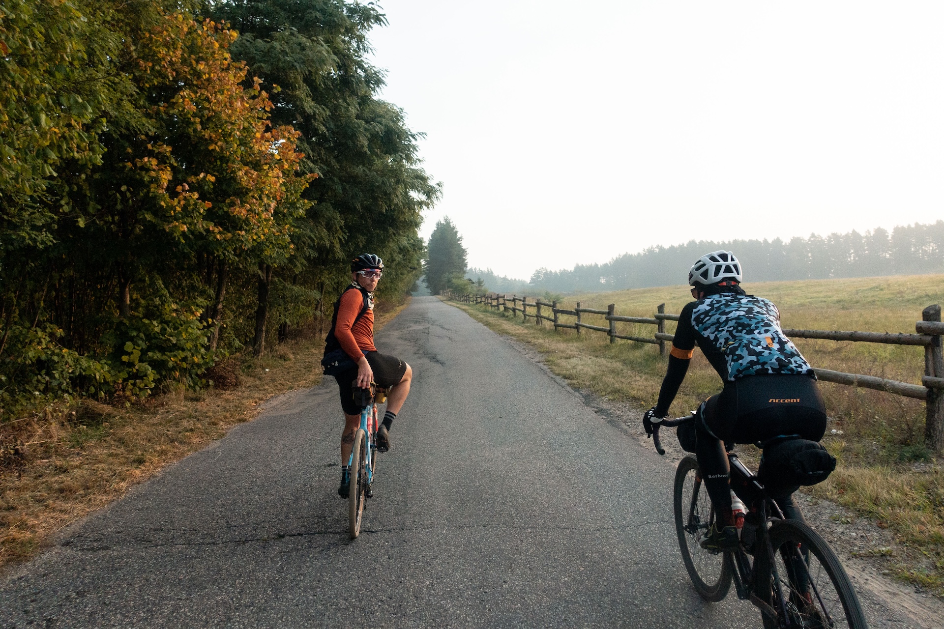 Bikepacking, dwoje kolarzy na drodze o wschodzie słońca