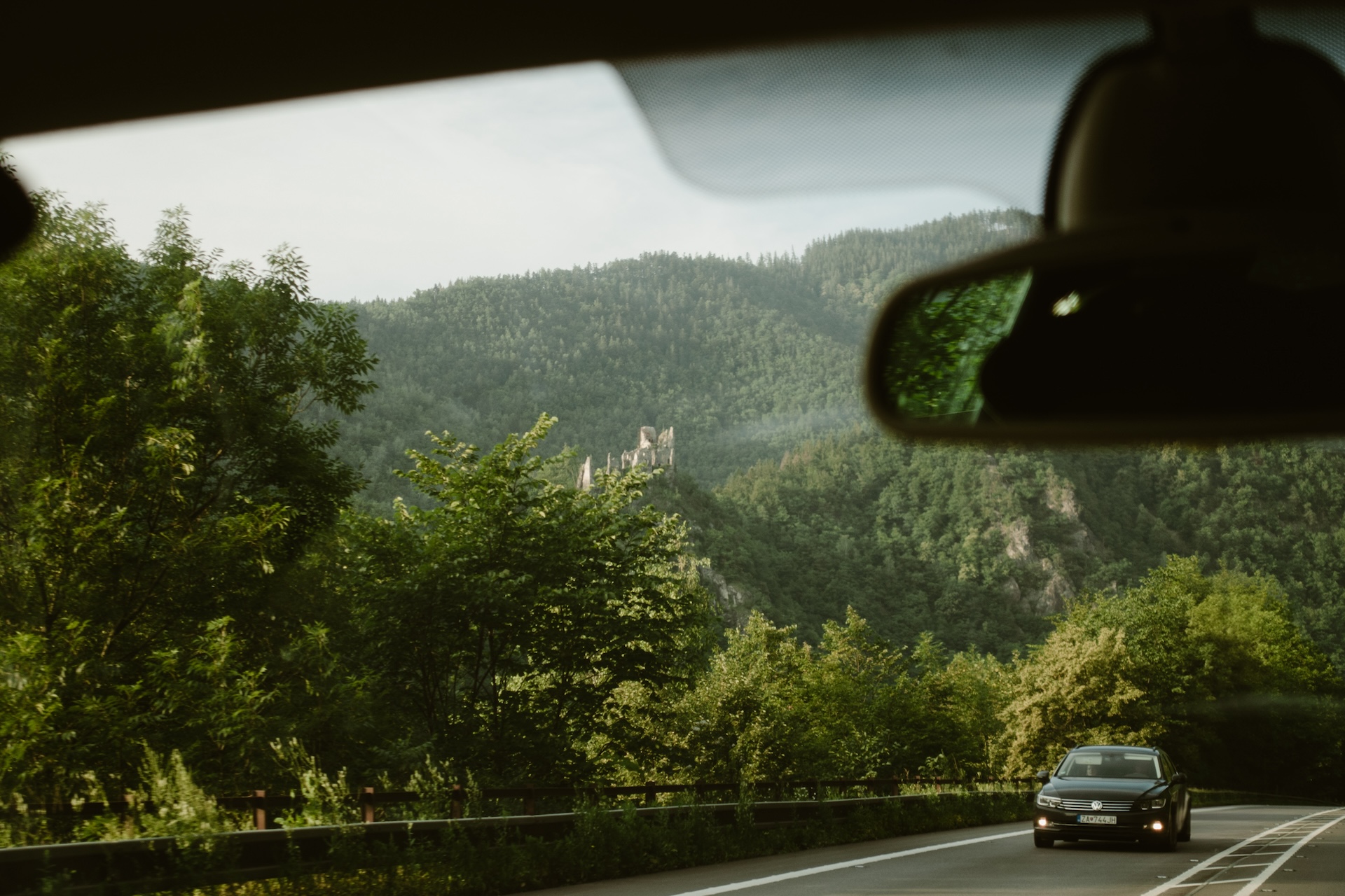 widok z samochodu na ruiny zamku na wzgórzu